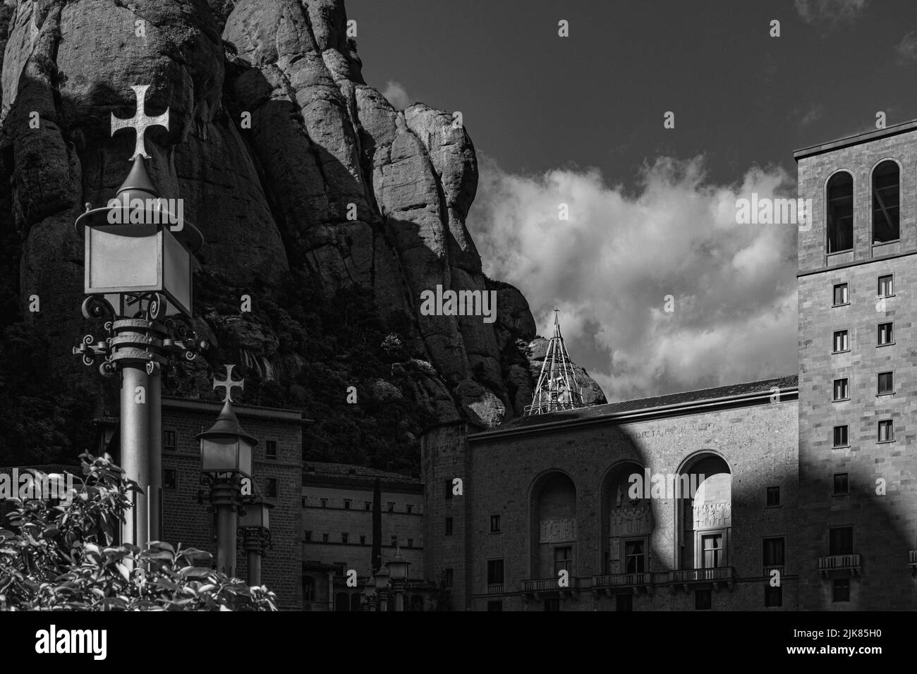 Vista in bianco e nero della facciata del Monastero di Montserrat nel tardo pomeriggio. I rilievi rocciosi della montagna di Montserrat elevano la spiritua Foto Stock