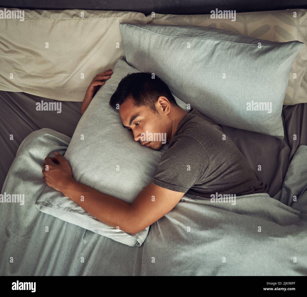 Non tutte le ferite sono visibili in superficie: Un giovane che si trova a letto e che non guarda a casa. Foto Stock