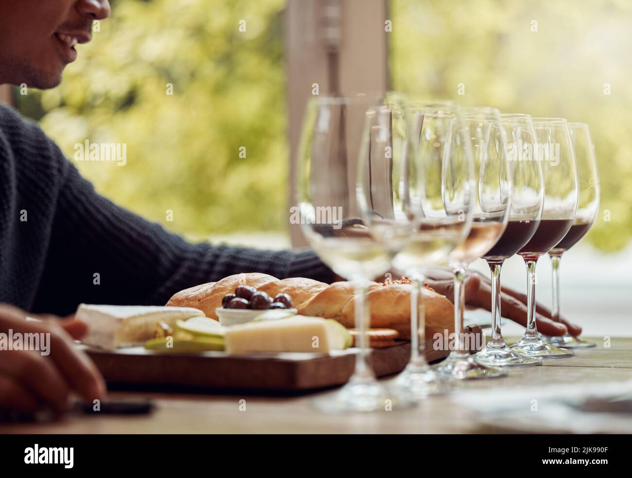 Il buon vino rende ancora più gustoso il buon cibo: Un uomo che gusta un piatto di formaggi e degusta vini diversi. Foto Stock