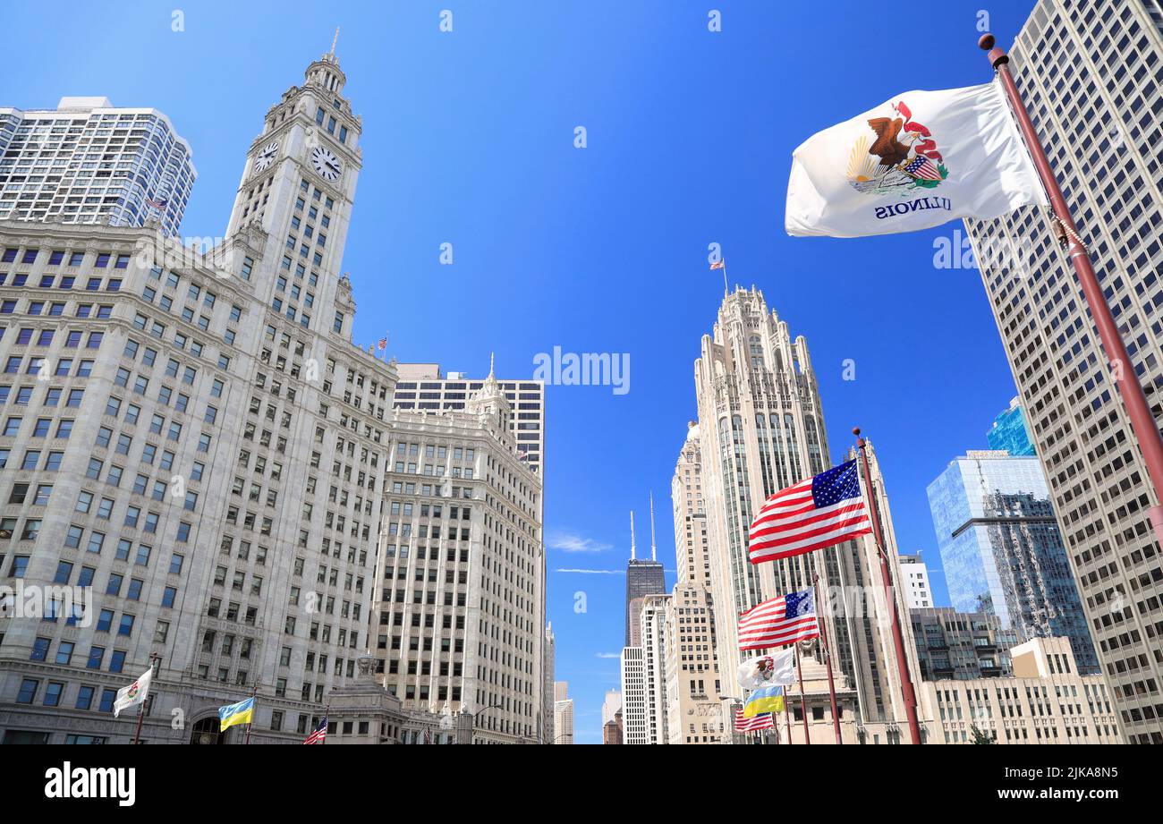 Wrigley Building e Tribune Tower su Michigan Avenue con Illinois bandiera sul primo piano in Chicago, Stati Uniti d'America Foto Stock