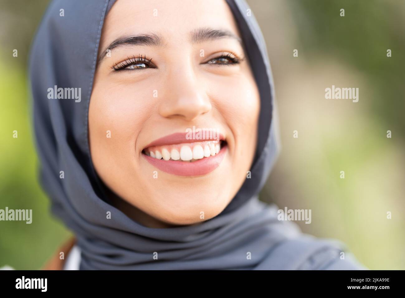 Attraente donna musulmana sorridente con un'espressione rilassata Foto Stock