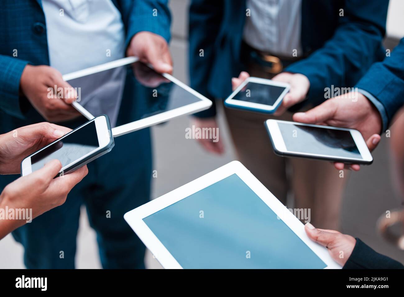 La tecnologia, non deve mai dire di nuovo Arrivederci. Un gruppo di uomini d'affari irriconoscibili che utilizzano i loro dispositivi mobili. Foto Stock