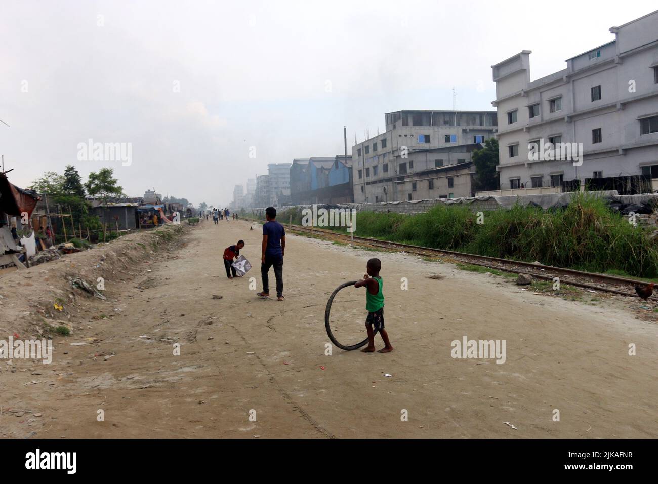 Le donne e i bambini sono vulnerabili condizionare un'area inquinata dall'aria quando il fumo sale da un laminatoio a Dhaka, Bangladesh, 30 luglio 2022. I livelli di inquinamento atmosferico in paesi in via di sviluppo come il Bangladesh, con una popolazione relativamente giovane, rappresentano per molti anni un rischio per la salute inadeguato, a meno che non vengano adottate misure significative di controllo ambientale. Foto di Habibur Rahman/ABACAPRESS.COM Foto Stock