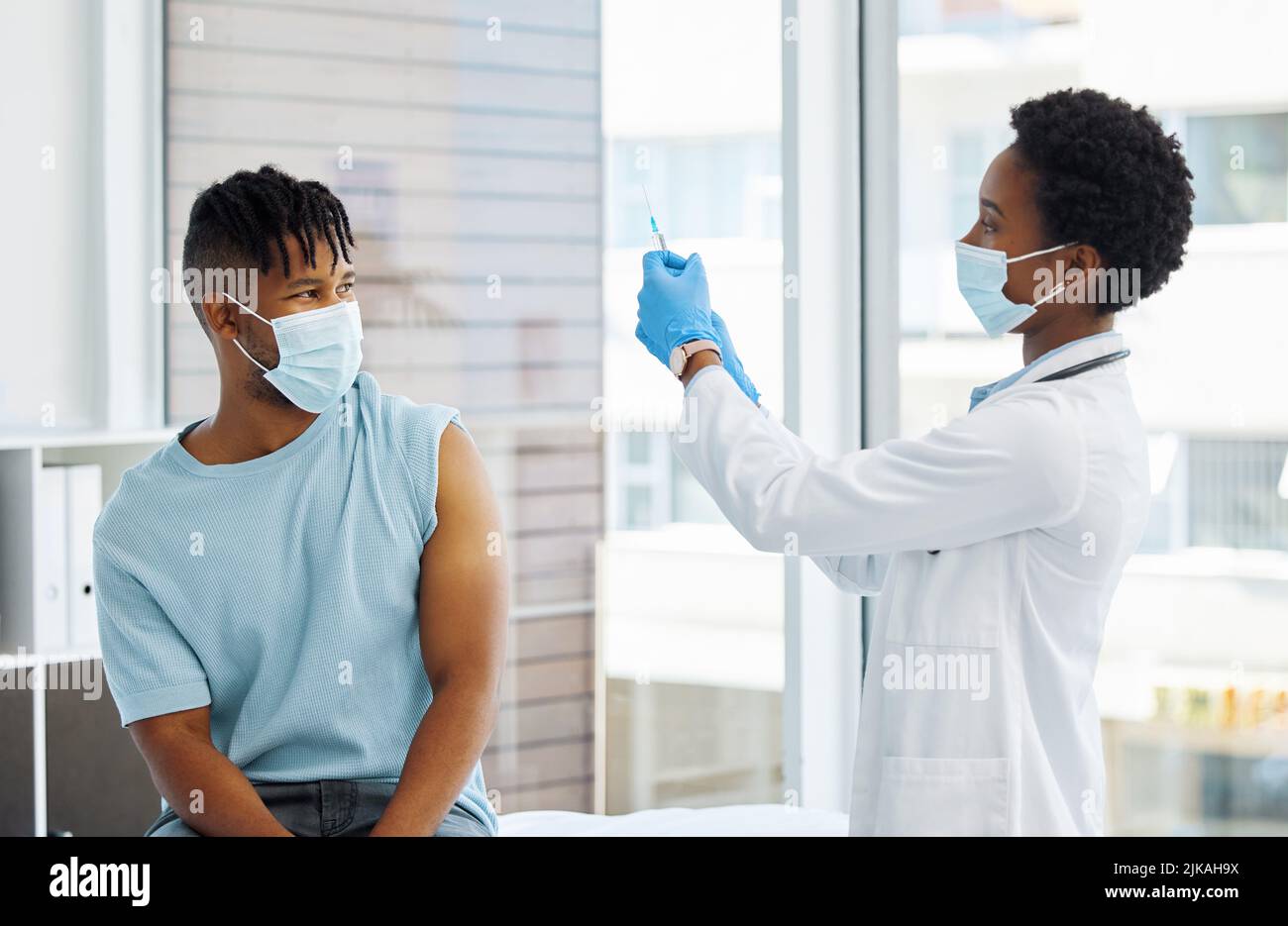 Il medico sta per iniettare il braccio di un paziente. Foto Stock