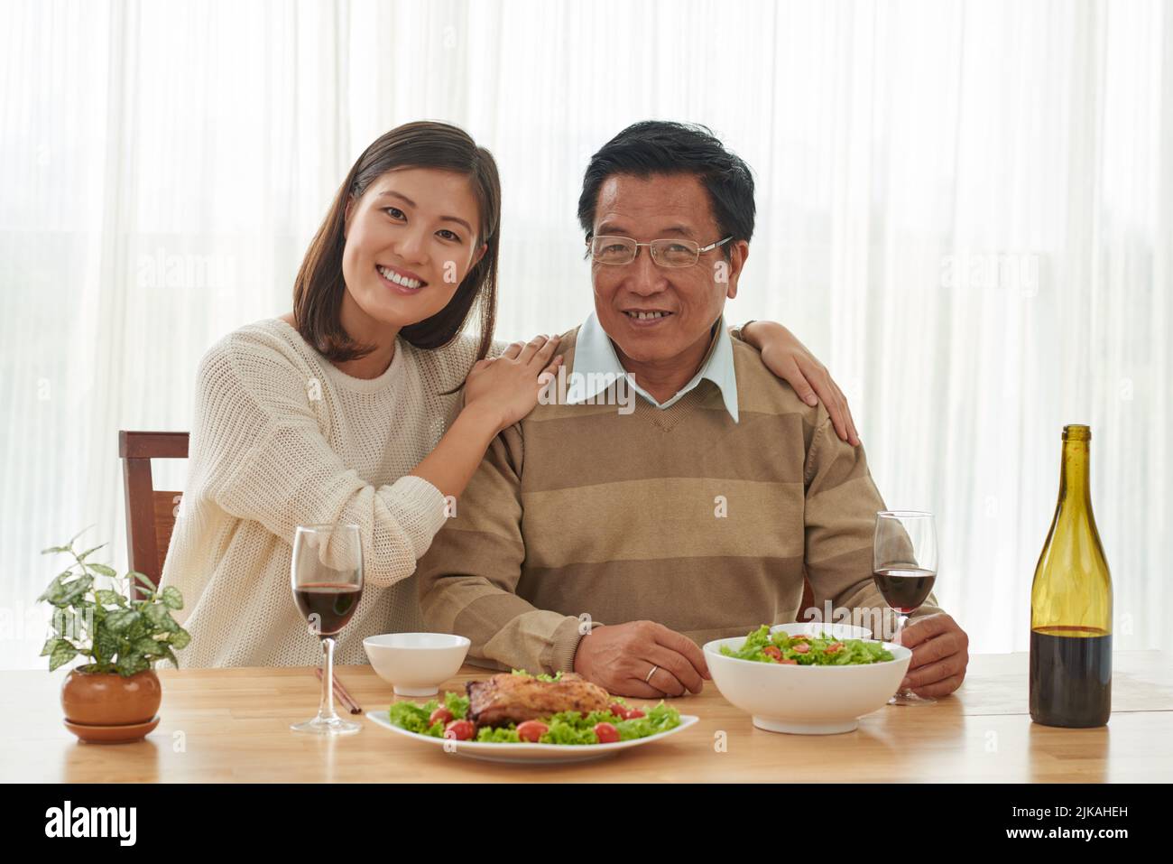 Ritratto di felice padre vietnamita e sua figlia adulta a cena a casa Foto Stock