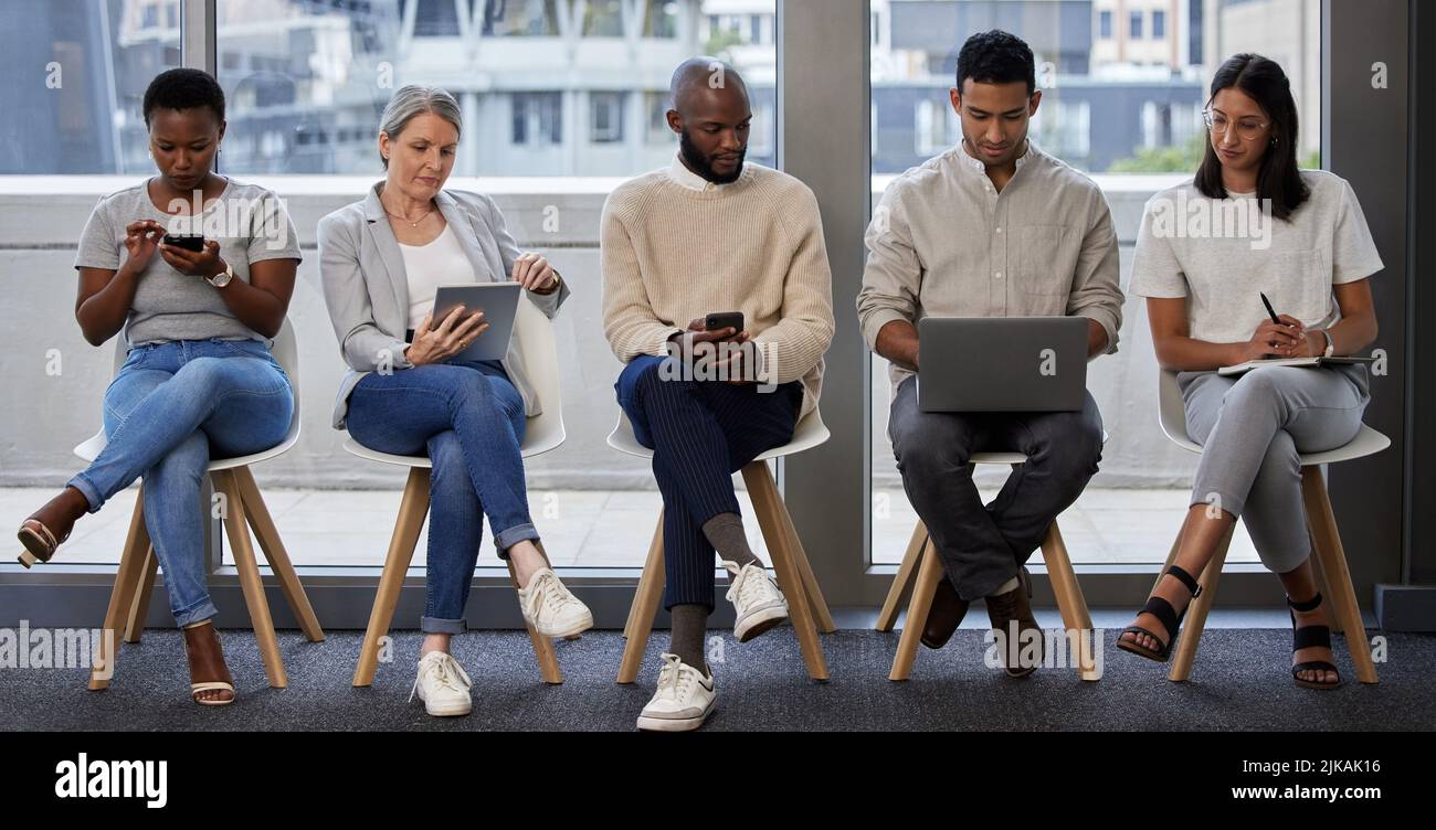 Ciò che vi rende diversi è ciò che vi fa notare: Un gruppo di uomini d'affari che utilizzano dispositivi wireless in attesa di un colloquio. Foto Stock
