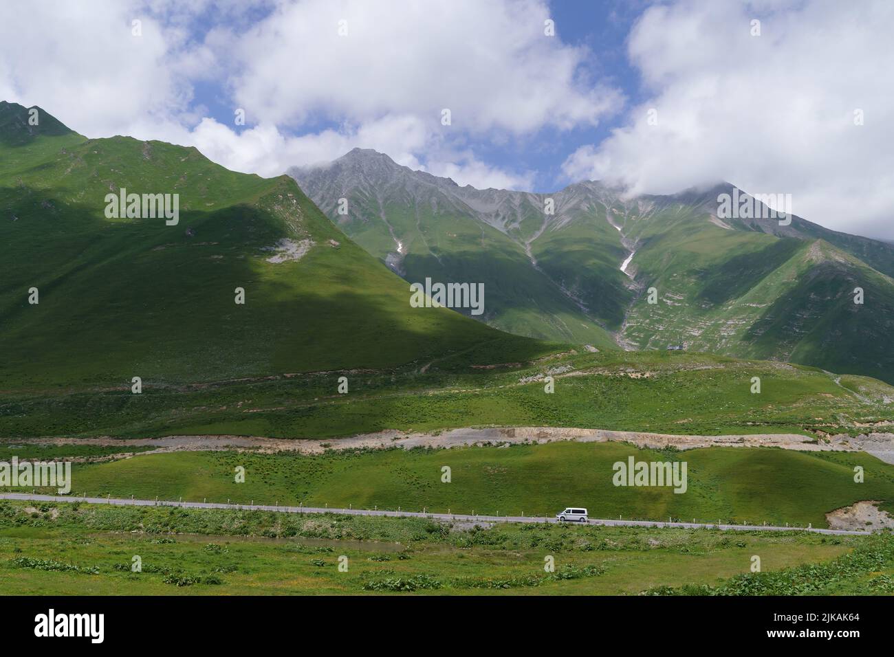 Attraversa la strada militare georgiana in estate e montagne giganti coperte di prati alpini Foto Stock