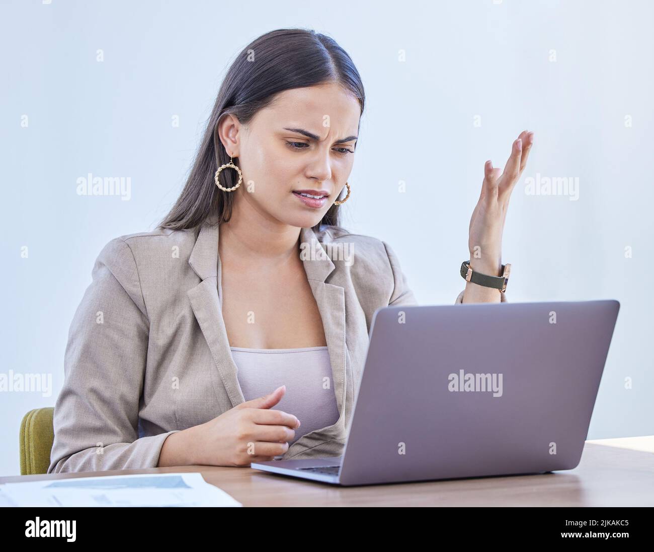 Perché sto lottando così tanto con questo. Una giovane donna che guarda turbata mentre lavora su un notebook in un ufficio. Foto Stock
