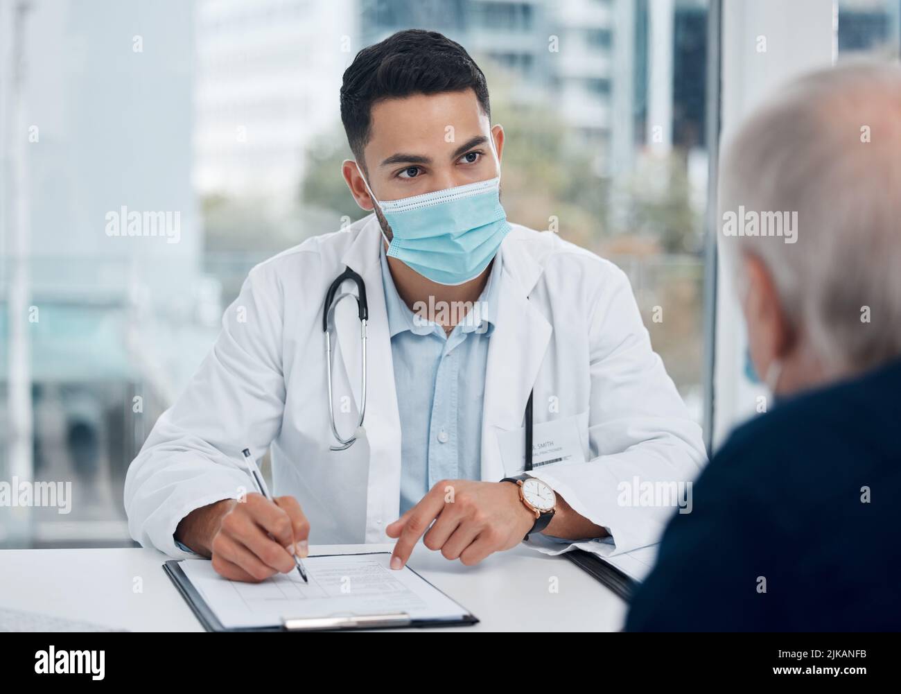 Ho appena qualche dettaglio da voi: Un giovane medico che parla con un paziente in un ufficio. Foto Stock