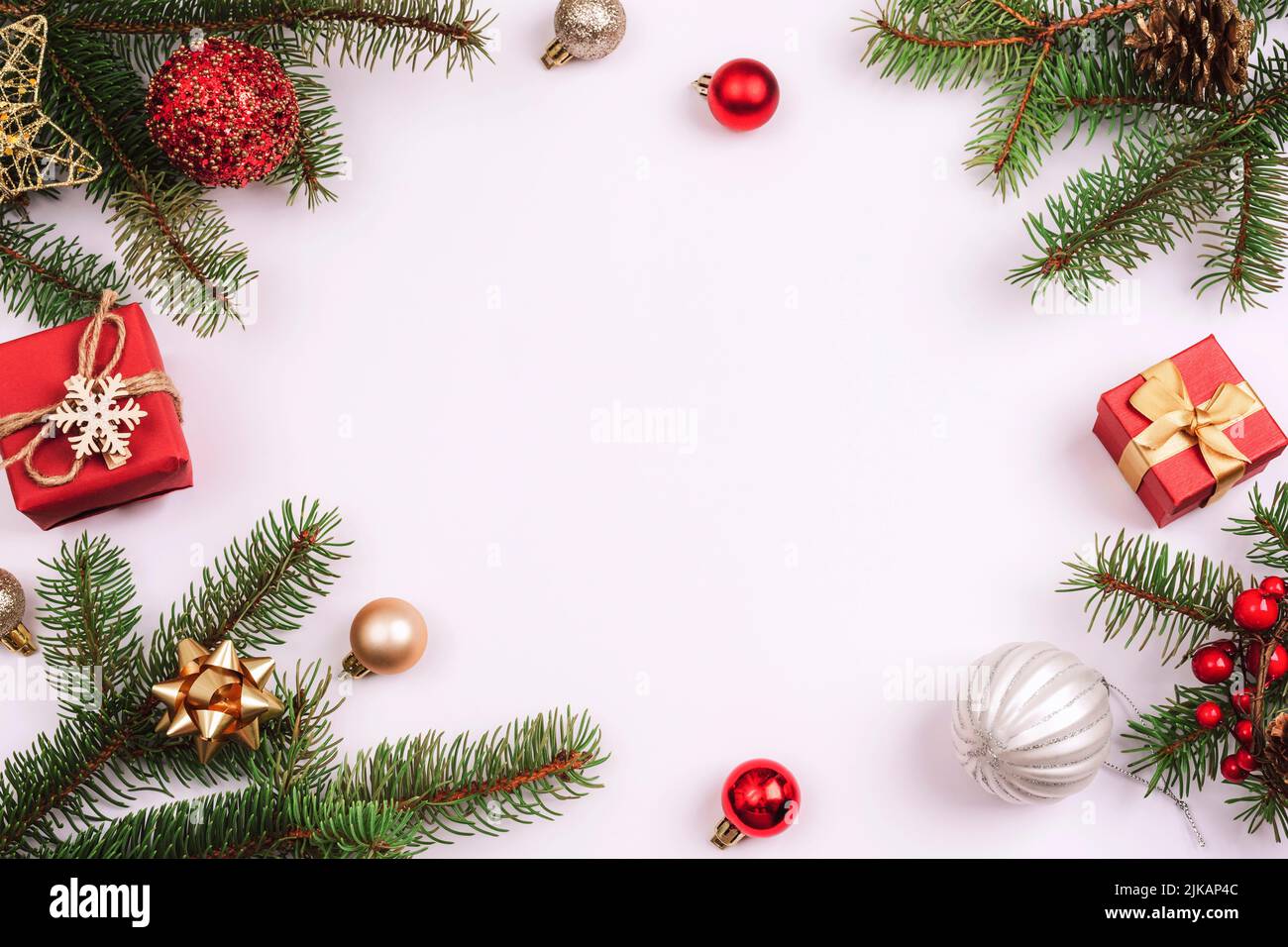 Sfondo natalizio, rami di abete, scatole regalo, palline rosse e decorazioni natalizie su sfondo bianco. Vista dall'alto, disposizione piatta, spazio di copia Foto Stock
