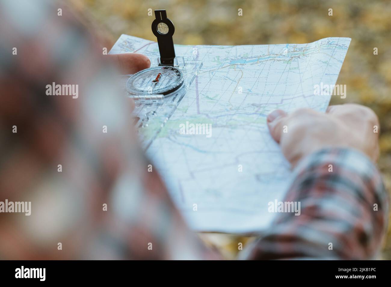 viaggiatore stile di vita uomo bussola mappa giallo erba Foto Stock