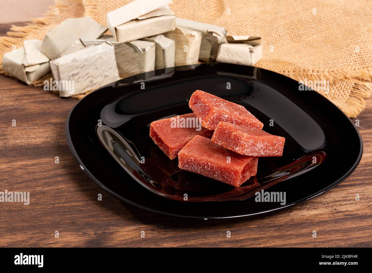 Pasta di guava avvolta in foglia di Bijao; foto su sfondo di legno Foto Stock