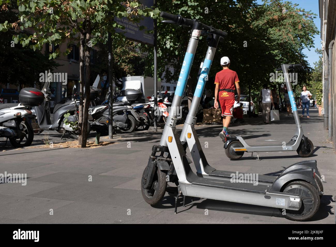 E-scooters o e-Steps della compagnia BIRD in affitto sono in attesa di clienti in una via commerciale a Roma. Mezzi di trasporto popolari lì Foto Stock