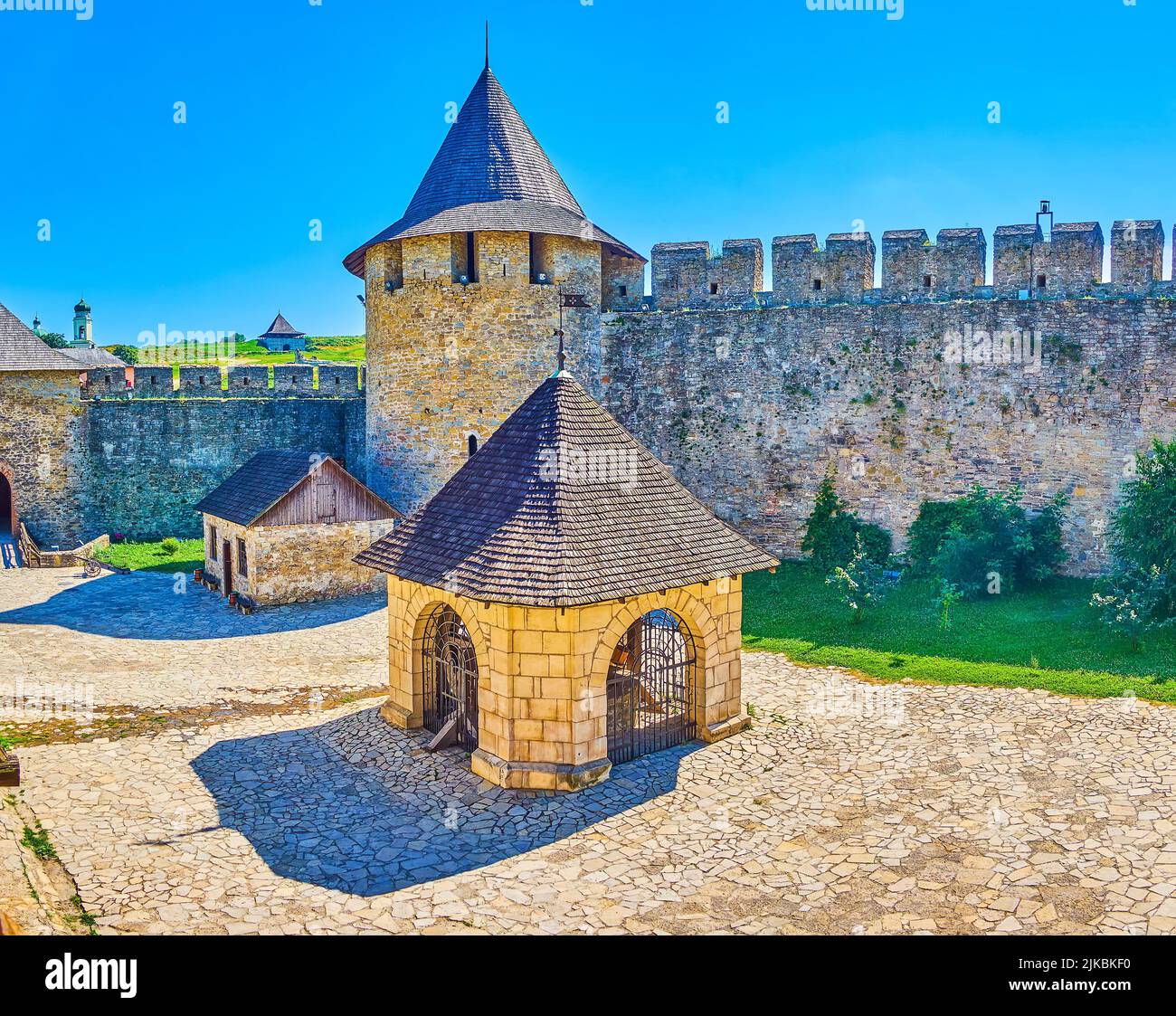 Il bellissimo cortile in pietra della Fortezza di Khotyn con massicci bastioni, torri e il pozzo, sormontato da un padiglione in pietra, Ucraina Foto Stock