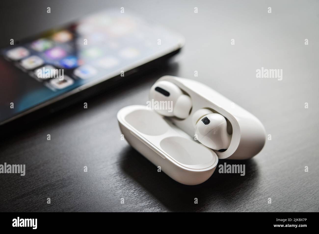 KIEV, UCRAINA - 10 FEBBRAIO 2022: Nuove cuffie AirPods Pro con Apple iPhone 13 Pro Space Grey su sfondo nero. Foto Stock