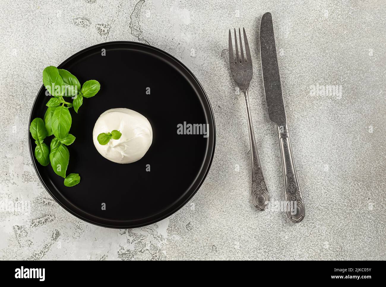 Servizio minimalistico. Burrata fresca di mozzarella italiana con una sorpresa interna, il centro è ripieno di panna. Foto Stock