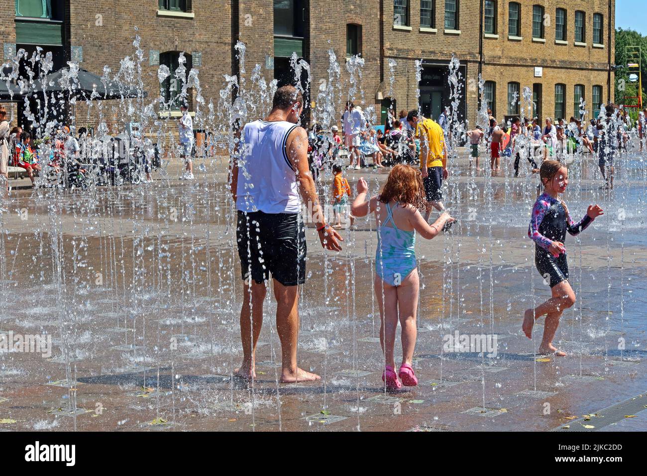 Bagnetti estivi, che si divertono a temperature record, a Granary Square, Kings Cross, Coal Drops Yard, Camden, Nord di Londra, Inghilterra, Regno Unito, N1C 4BH Foto Stock