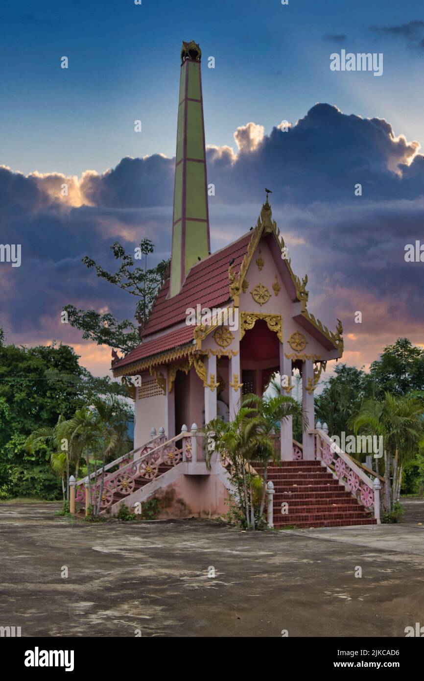 Crematorio di un tempio di villaggio buddista a Phetchabun, Thailandia, sotto un cielo drammatico. Foto Stock