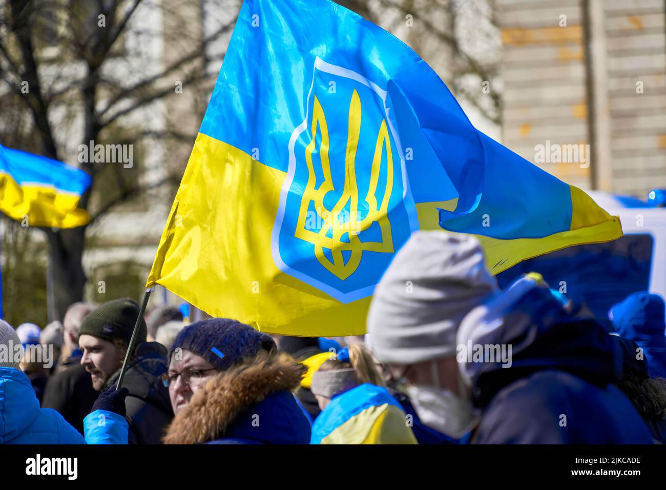 Hannover, Germania, 10 aprile 2022: Bandiera dell'Ucraina con lo stemma del paese vola sui capi dei manifestanti contro la Russia A. Foto Stock