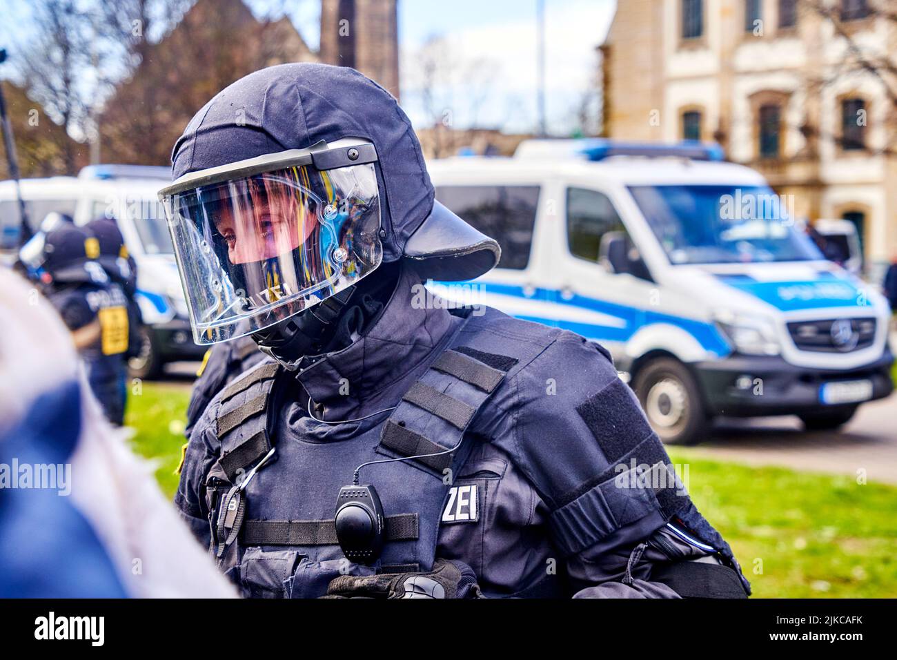 Hannover, Germania, 10 aprile 2022: Giovane ufficiale di polizia in uniforme nera e tuta protettiva con visiera sul casco al bordo di una dimostrazione Foto Stock