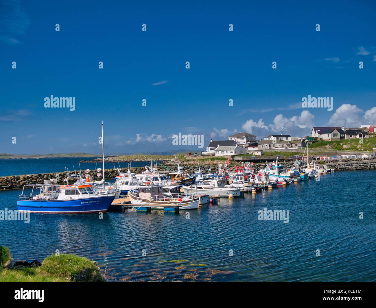 Le barche locali per la pesca e il tempo libero ormeggiate a Hamnavoe Marina su Mainland, Shetland, Scozia, Regno Unito - in una giornata tranquilla e soleggiata. Foto Stock