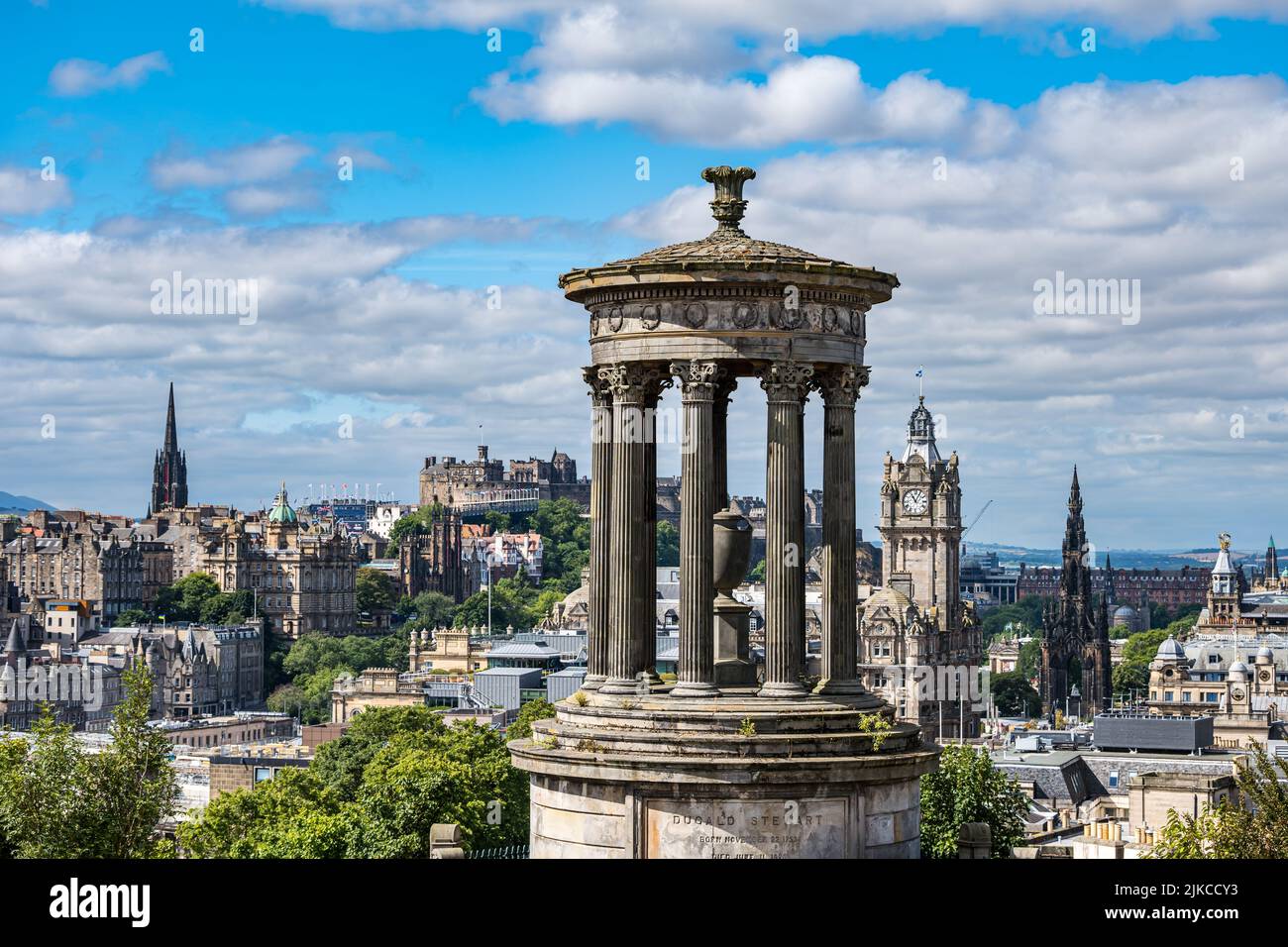 Vista iconica del monumento di Dugald Stewart sullo skyline della città con il castello di Edimburgo e la torre dell'orologio dell'hotel Balmoral, Edimburgo, Scozia, Regno Unito Foto Stock