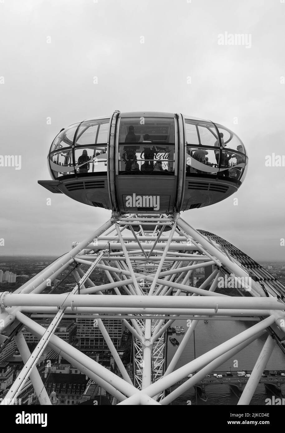Una foto verticale del London Eye pod che domina il paese nel Regno Unito in scala di grigi Foto Stock