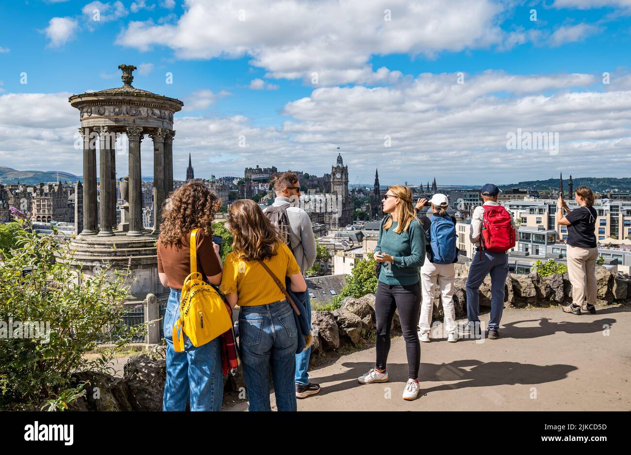 I turisti scattano foto dall'iconico punto panoramico di Calton Hill sullo skyline della città, Edimburgo, Scozia, Regno Unito Foto Stock