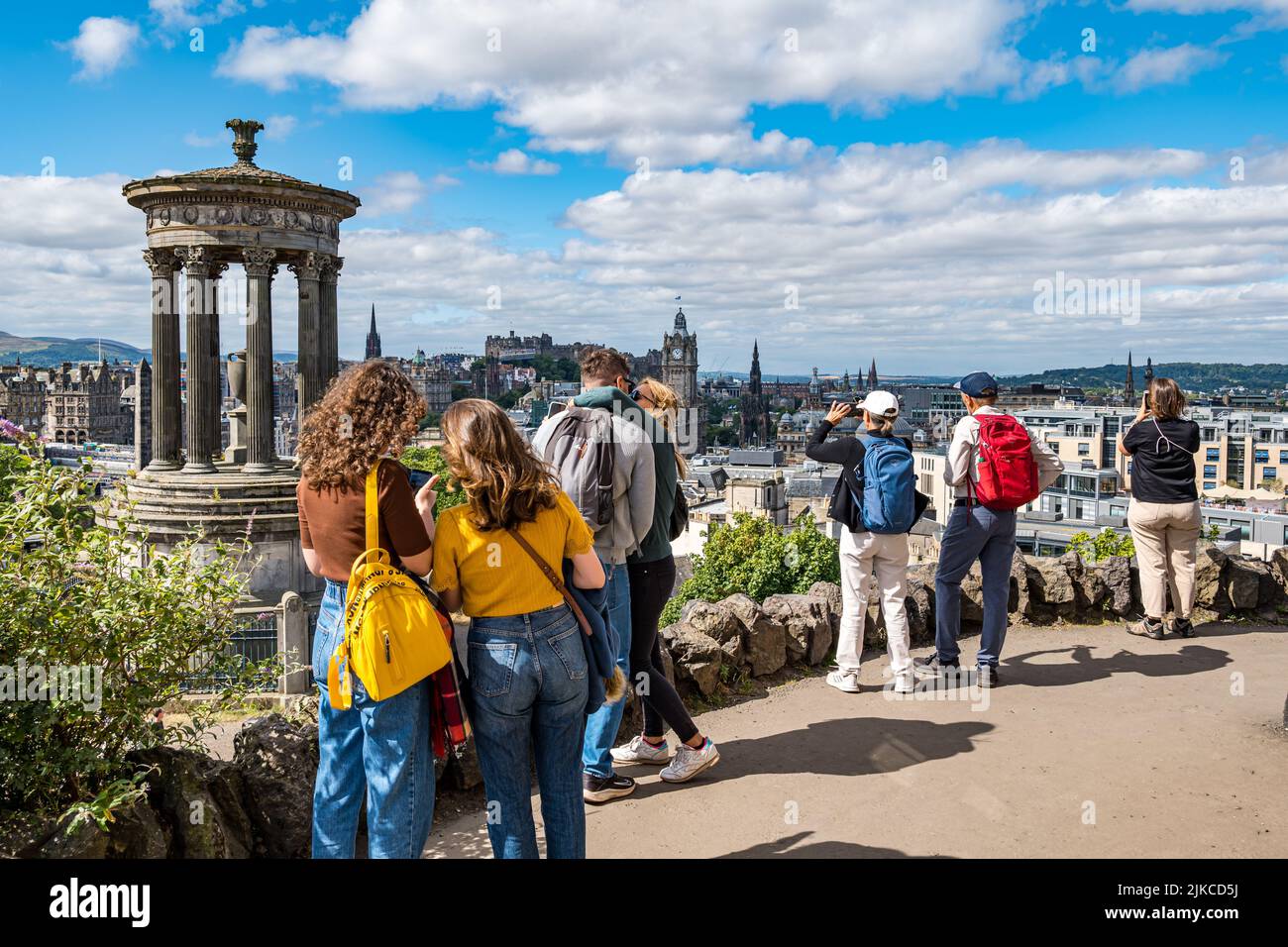 I turisti scattano foto dall'iconico punto panoramico di Calton Hill sullo skyline della città, Edimburgo, Scozia, Regno Unito Foto Stock