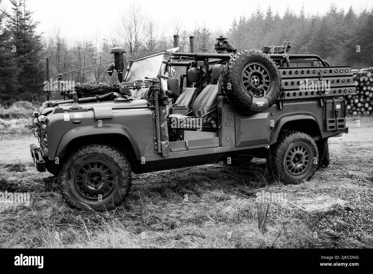 Una vista di una Land Rover WMIK fuoristrada nella foresta in scala di grigi Foto Stock