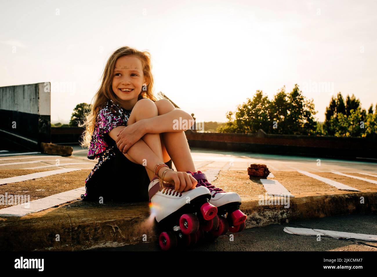 ritratto di una giovane ragazza nei suoi stivali a rullo felice al tramonto Foto Stock