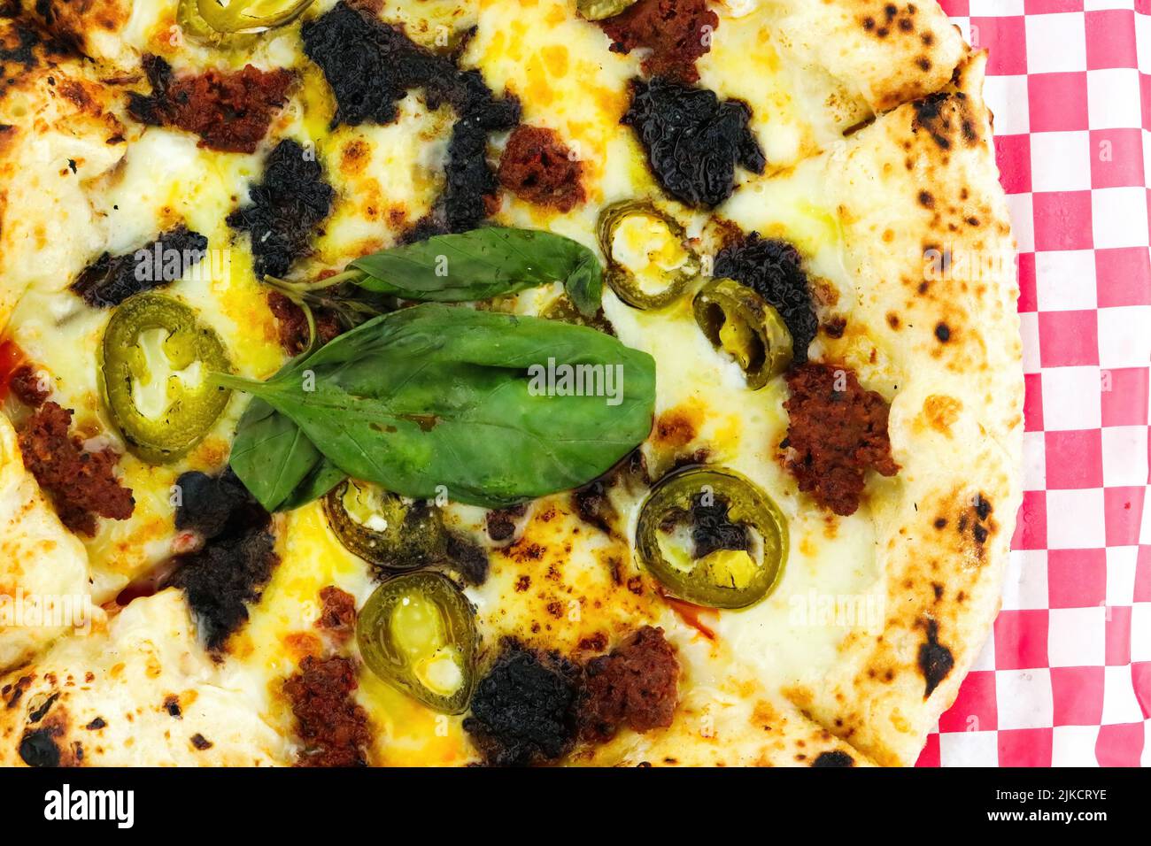 Pizza di manzo al pepe nero su carta a scacchi rossa Foto Stock