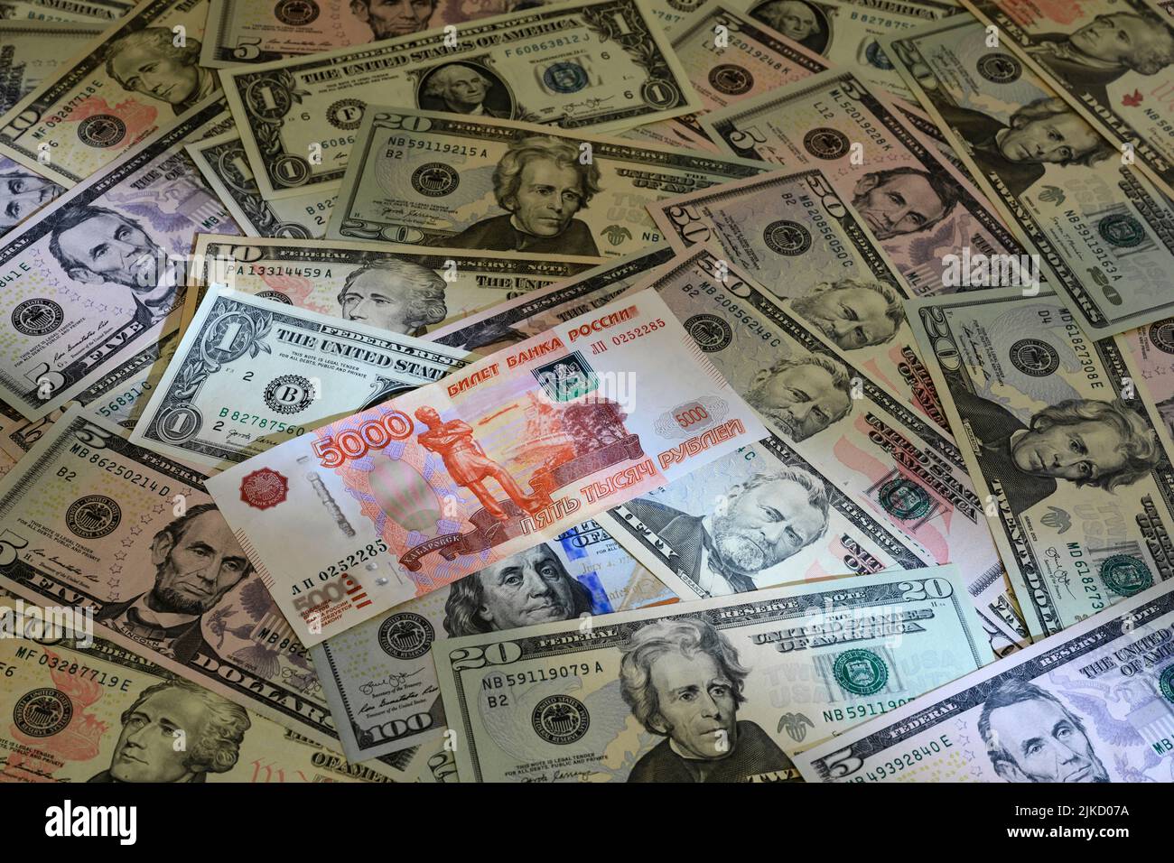 Banconota russa di 5000 rubli sullo sfondo delle banconote in dollari degli Stati Uniti Foto Stock