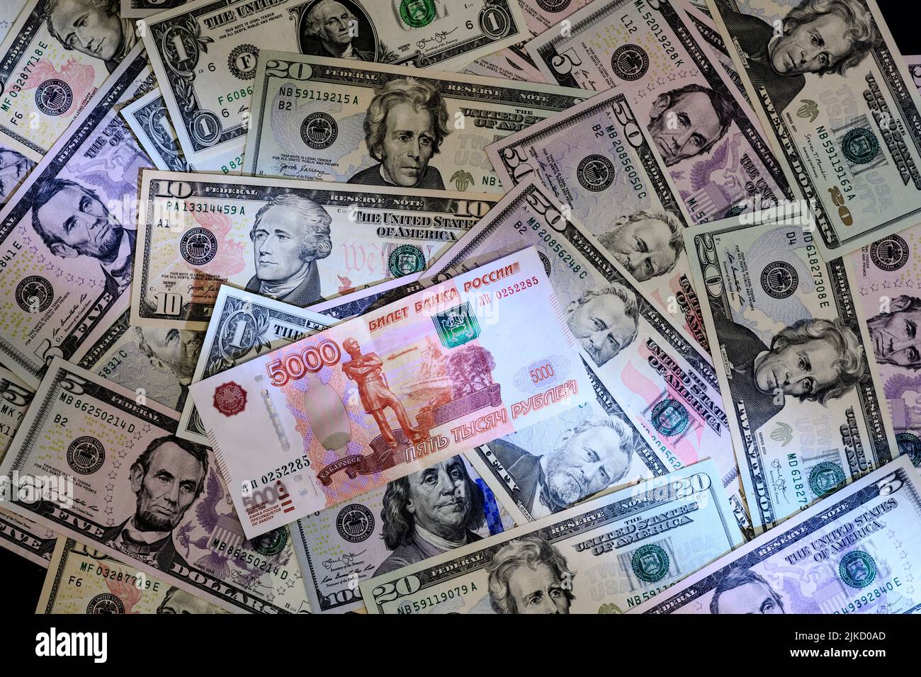 Banconota russa di 5000 rubli sullo sfondo delle banconote in dollari degli Stati Uniti Foto Stock