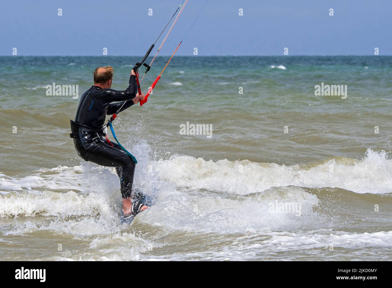 Kiteboarder / kitesurfer indossare muta su tavola doppia kitesurf sul Mare del Nord Foto Stock