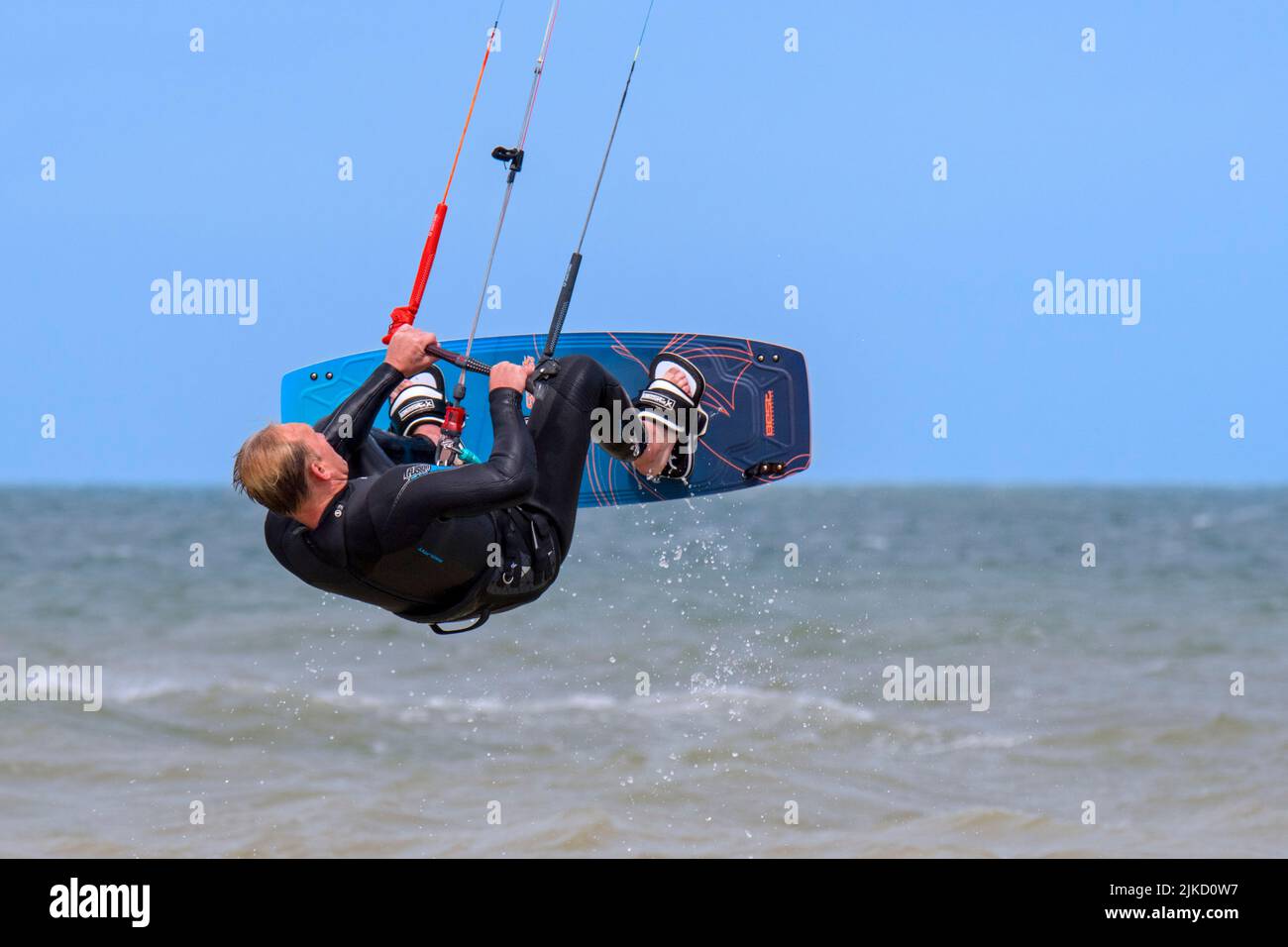 Kitesurf mostra kiteboarder / kitesurfer sulla tavola a punta doppia saltando sul Mare del Nord in una giornata ventosa Foto Stock