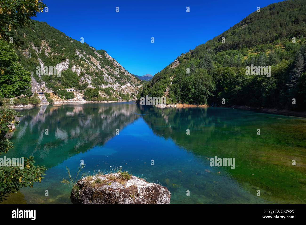 Piccolo lago circondato da montagne e speroni rocciosi, nel cuore verde di una natura quasi incontaminata. Lago di San Domenico, Abruzzo - Italia Foto Stock