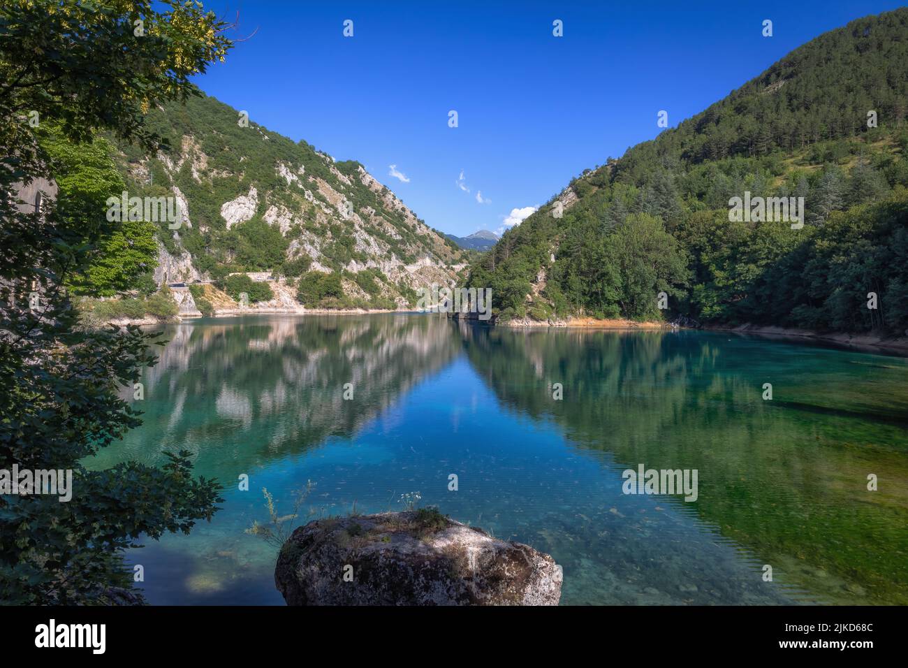 Piccolo lago circondato da montagne e speroni rocciosi, nel cuore verde di una natura quasi incontaminata. Lago di San Domenico, Abruzzo - Italia Foto Stock