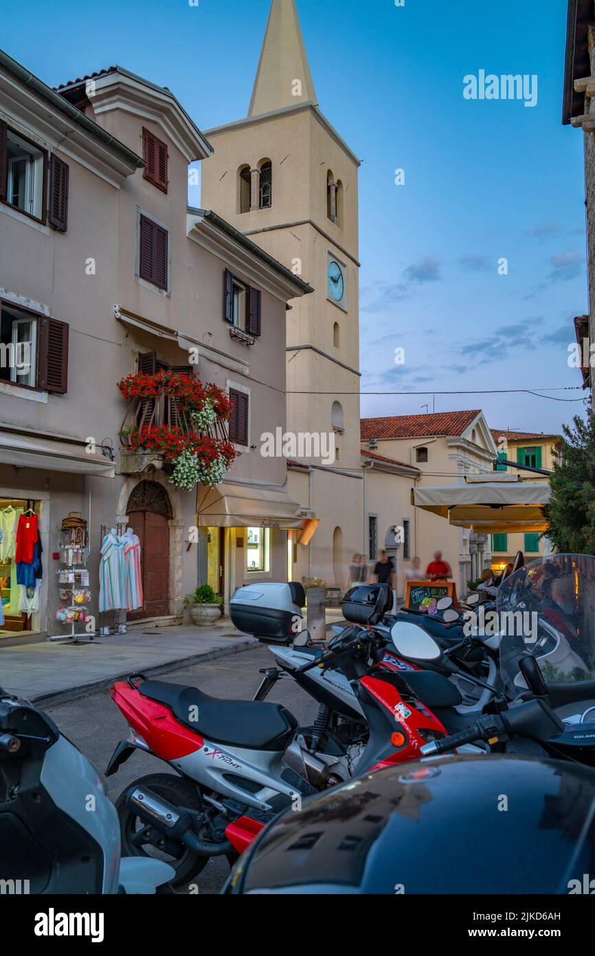Vista della Chiesa di San Giorgio e dei negozi al tramonto nel villaggio di Lovran, Lovran, baia di Kvarner, Istria orientale, Croazia, Europa Foto Stock