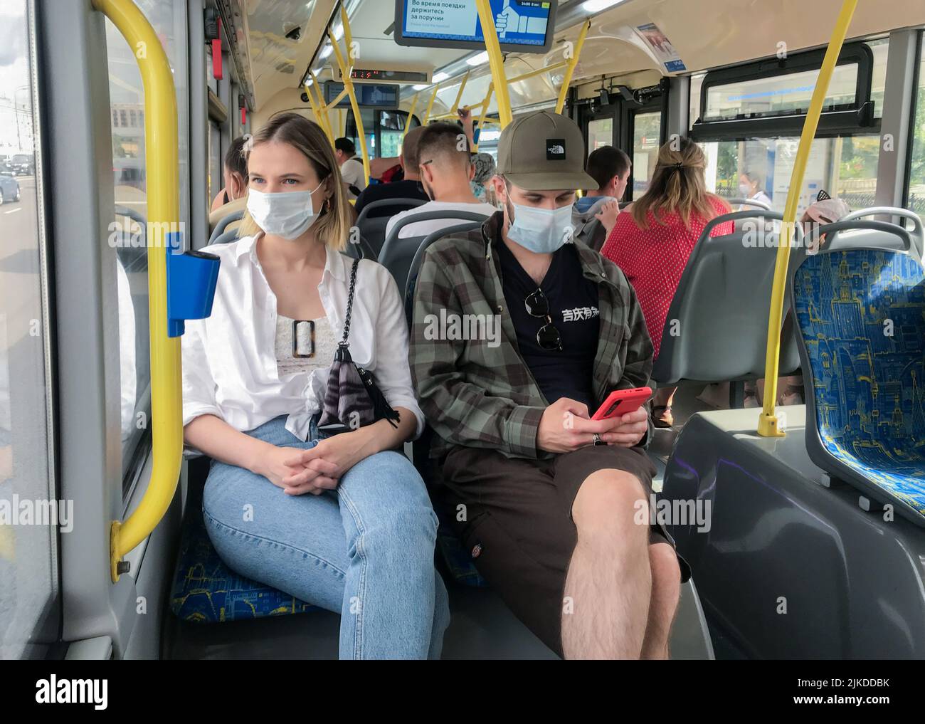 Mosca, Russia, agosto 2020: Passeggeri su un autobus che indossa maschere mediche protettive. Foto Stock