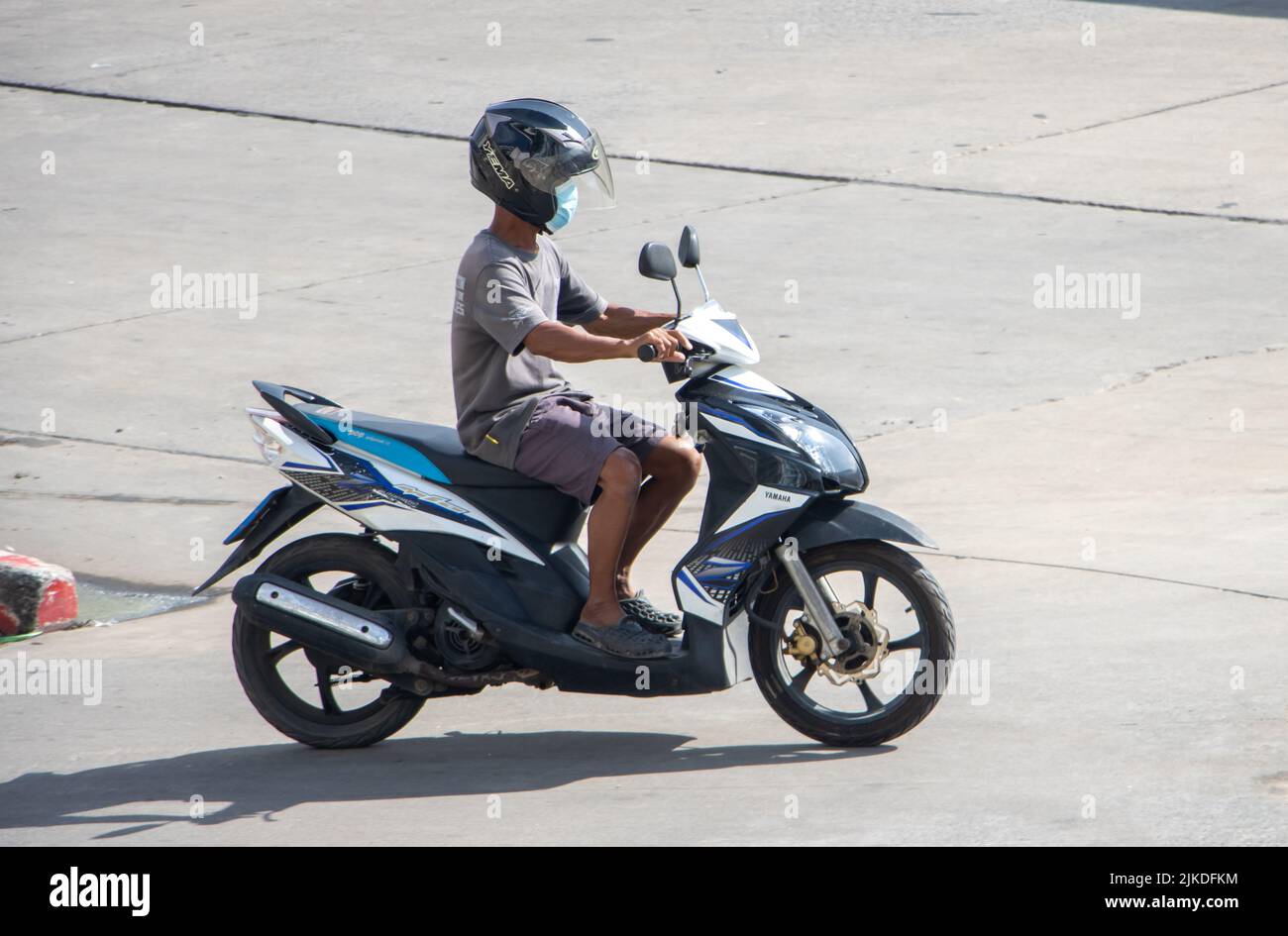 SAMUT PRAKAN, THAILANDIA, 30 2022 MAGGIO, Un uomo con casco corre una moto sulla strada soleggiata Foto Stock