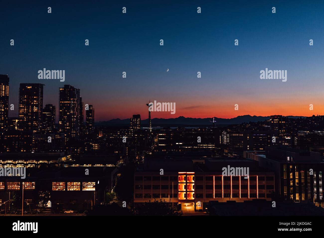 Tramonto con lo skyline del centro di Seattle, le Olympic Mountains, luna crescente dal ponte sul tetto di Capitol Hill Foto Stock