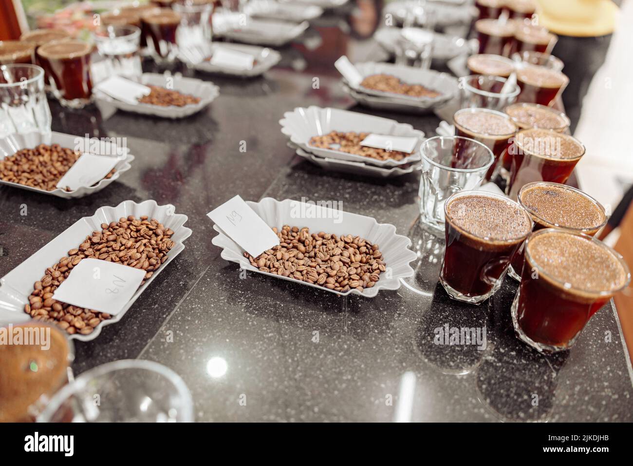 Bicchieri e fagioli da caffè sul tavolo pronti per una degustazione al chiuso Foto Stock