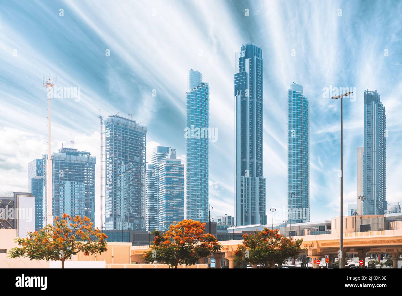 La gru da cantiere è impegnata nello sviluppo di un nuovo edificio residenziale a più piani. Vista dei moderni grattacieli di Dubai. Sviluppo delle costruzioni Foto Stock