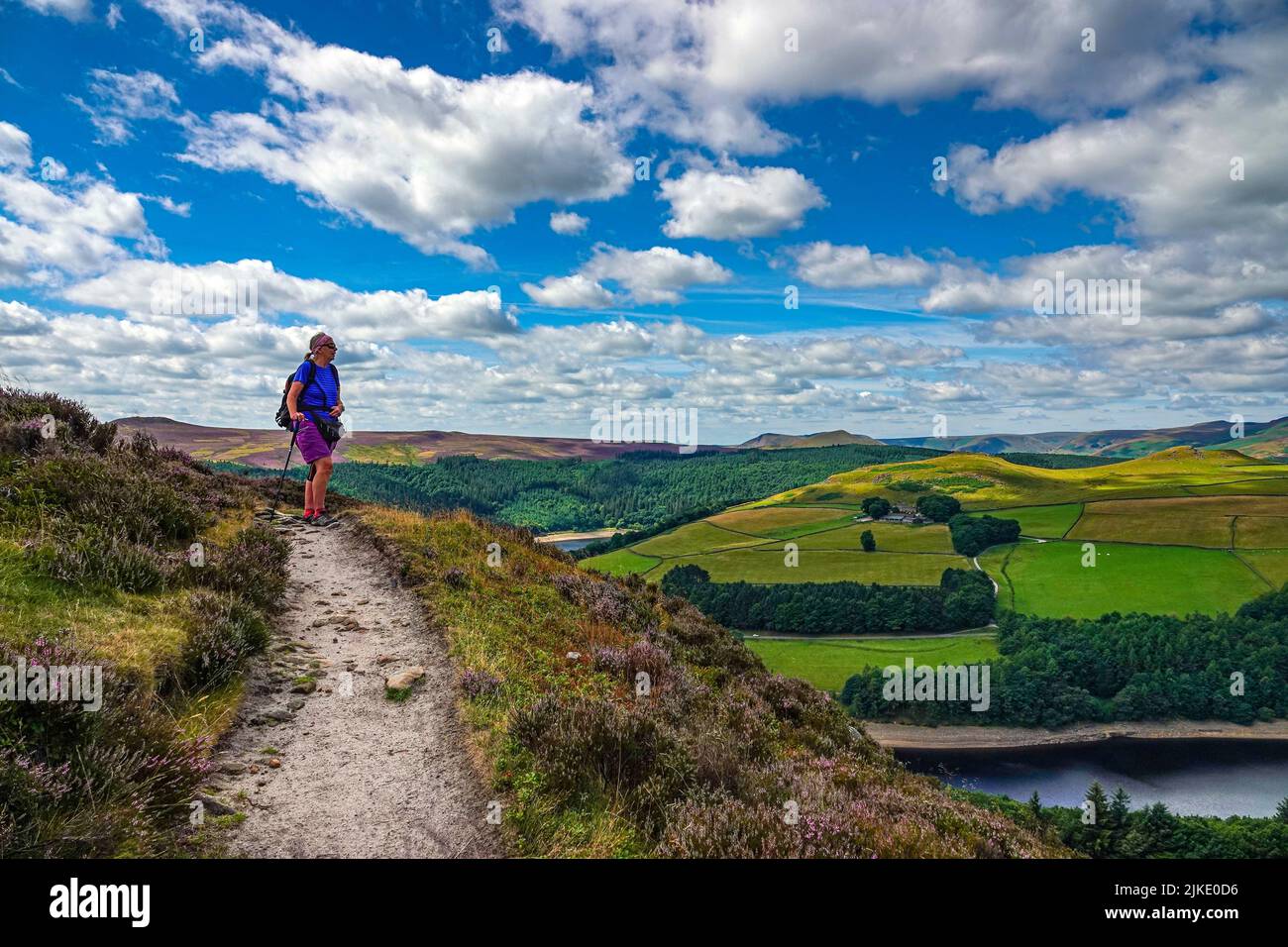 Lone femmina escursionista sopra Ladybower Reservoir visto dall'alto, da Derwent Edge, Peak District National Park, Derbyshire, Regno Unito Foto Stock