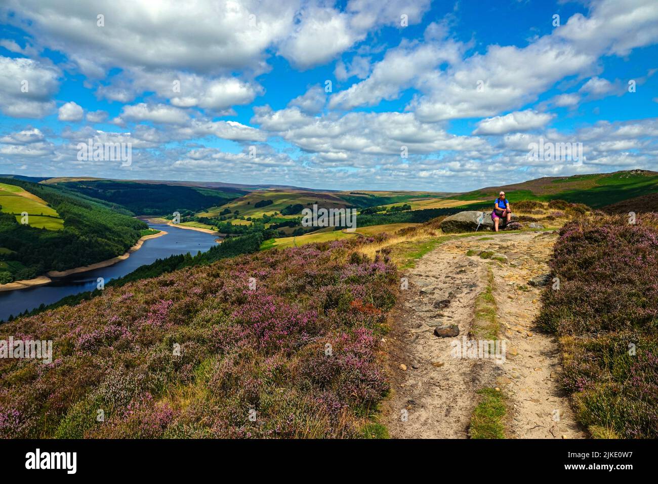 Lone femmina escursionista sopra Ladybower Reservoir visto dall'alto, da Derwent Edge, Peak District National Park, Derbyshire, Regno Unito Foto Stock