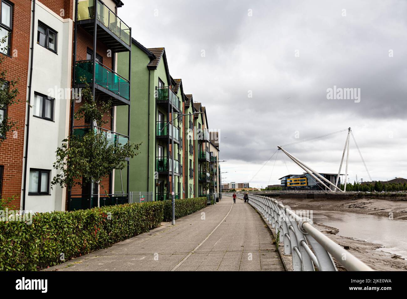 Moderni edifici di appartamenti lungo il fiume Usk, e il ponte pedonale di Newport City, Newport, Monmouthshire, Galles del Sud, Regno Unito. Foto Stock