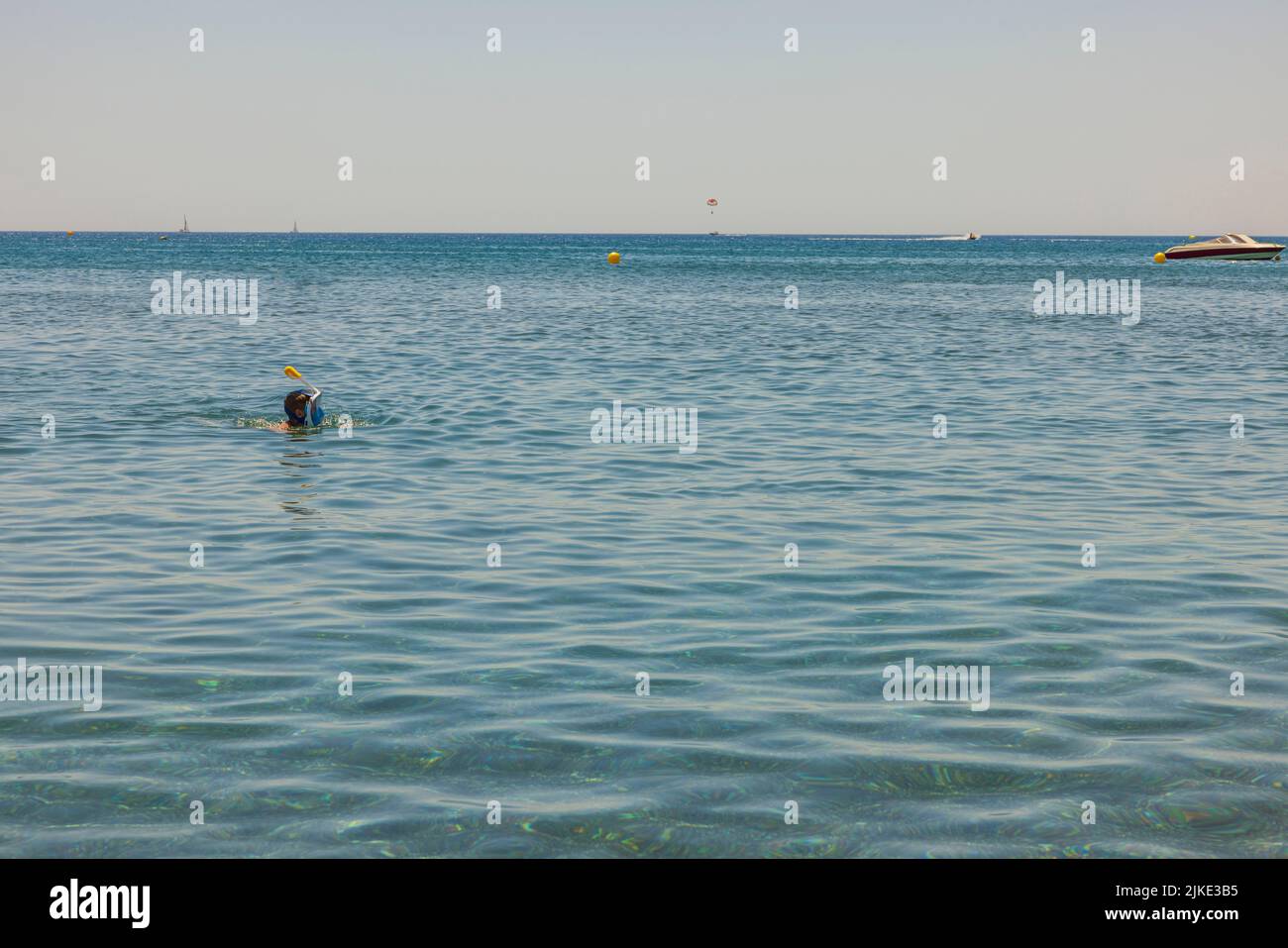 Vista dell'uomo nella maschera da snorkeling sulla superficie blu dell'acqua di mare. Grecia. Foto Stock