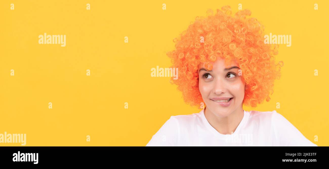 donna freaky sognante in clown wig ricci immaginare qualcosa, immaginazione. Donna ritratto isolato volto, banner con spazio copia Foto Stock