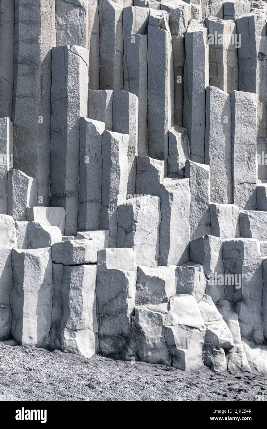 Dettaglio delle colonne di basalto alla base della scogliera di Reynisfjall nella spiaggia di Reynisfjara nell'Islanda meridionale Foto Stock